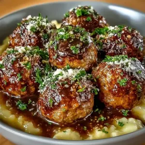 Slow cooker Salisbury steak meatballs served on a plate with gravy and mashed potatoes.