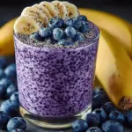Delicious Banana-Blueberry Smoothie in a glass with fresh fruit toppings
