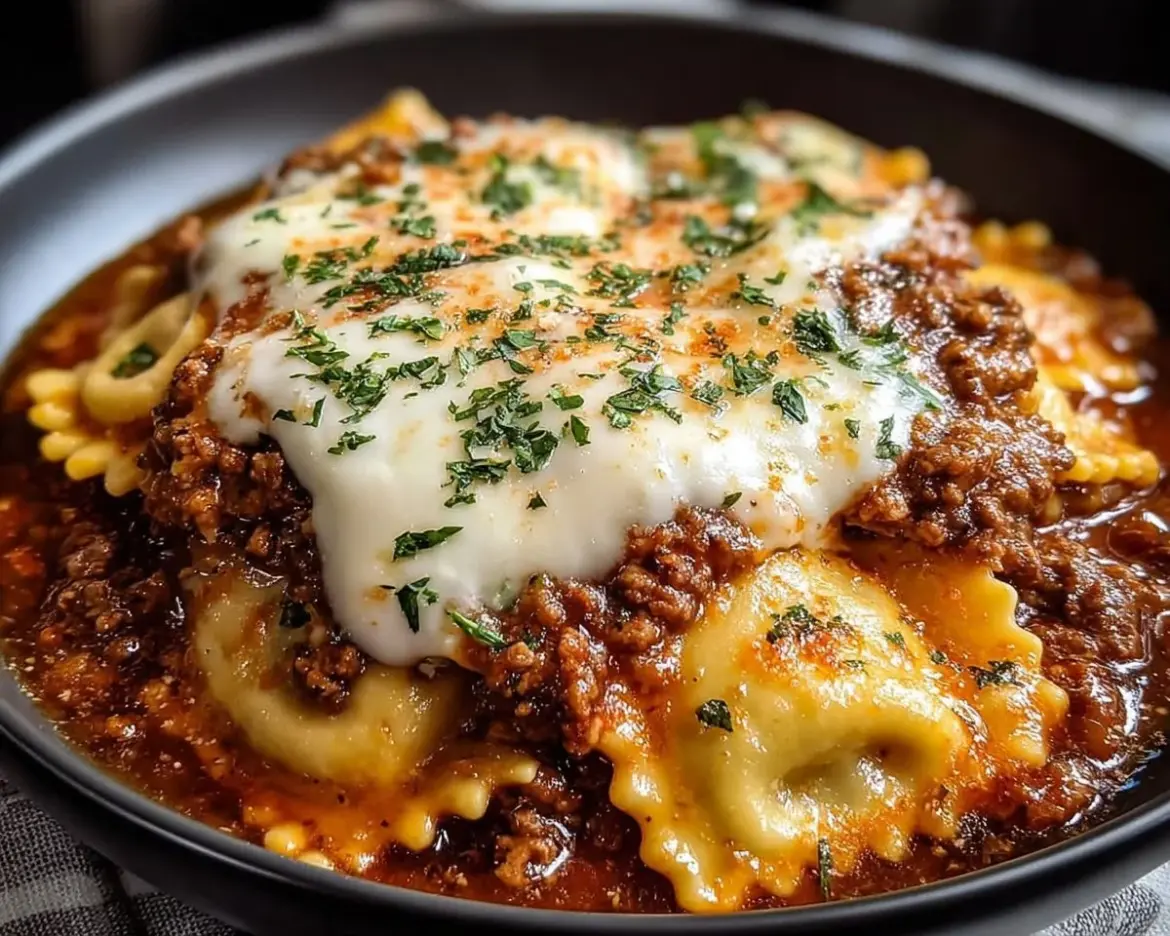 Crockpot Ravioli Lasagna topped with cheese and fresh herbs in a slow cooker
