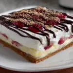 Layered banana split dessert with ice cream, fresh bananas, and toppings