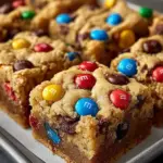 Delicious M&M cookie bars stacked on a plate