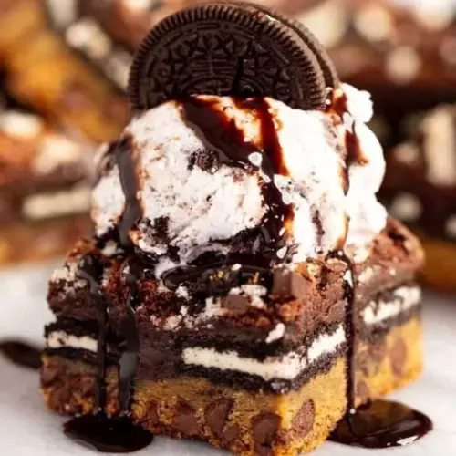 Ultimate Slutty Brownies with layers of cookie dough and Oreos